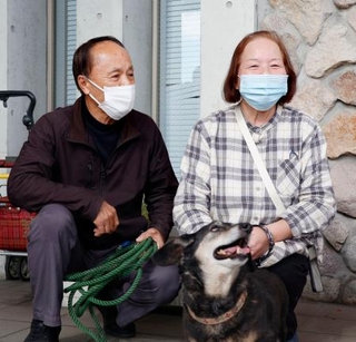 　愛犬のミノと約１日半ぶりに再会した渡辺敏夫さん（左）と妻の寿賀子さん＝２０日午前、大分市佐賀関