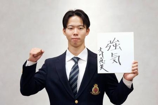 　日本ハムへの入団が決まり、色紙を手にポーズをとる明大の大川＝２１日、東京都内