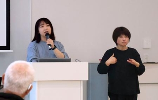 　「東日本大震災・原子力災害伝承館」で震災の経験を語る小泉良空さん（左）と手話通訳の高橋富士子さん＝２４日、福島県双葉町