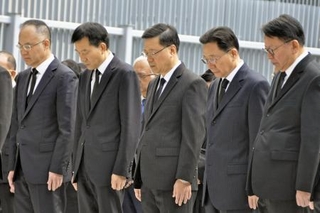 　香港政府庁舎の広場で黙とうする李家超行政長官（中央）ら＝２９日（共同）