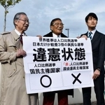 　参院選の「１票の格差」訴訟の判決を受け、広島高裁松江支部前で「違憲状態」などと書かれた紙を掲げる原告側の升永英俊弁護士（左）ら＝４日午後、松江市