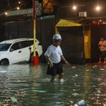 　台風が直撃し浸水した道路を歩く男性＝９日、マニラ首都圏（ゲッティ＝共同）