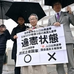 　「１票の格差」訴訟の判決を受け、札幌高裁前で「違憲状態」などと書かれた紙を掲げる原告側の升永英俊弁護士（右から２人目）ら＝１０日午後