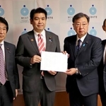 　自民党の「大学病院を支援する議員連盟」の松野博一会長（中央右）から緊急決議を受け取る松本文科相＝１１日午後、文科省