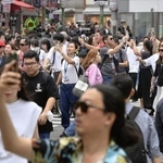 　スマホを手にスクランブル交差点を行き交う人たち＝東京・渋谷