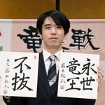 　竜王戦５連覇から一夜明け、色紙を手に写真に納まる藤井聡太竜王＝１４日午前、京都市下京区