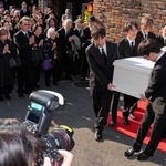 　出棺のため関係者に運ばれる仲代達矢さんのひつぎ。参列する役所広司さん（左奥）の姿もあった＝１４日午後、東京都世田谷区