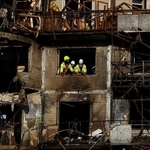 　１４日、ウクライナ・キーウで、ロシアの攻撃を受けた建物で活動する救助隊員ら（ロイター＝共同）