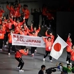 　「東京デフリンピック」の開会式で入場行進する日本選手団。旗手は空手女子の小倉涼＝１５日、東京体育館