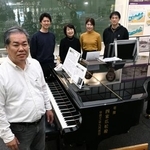 　大規模修復が必要になった「奇跡のピアノ」を囲む調律師遠藤洋さん（手前）と家族＝１０月、福島県いわき市