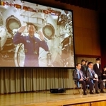 　母校の村立川上中で開かれたイベントで、宇宙から村民らと交信する油井亀美也さん（画面）＝１７日夜、長野県川上村