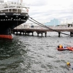 　女性とみられる上半身だけの遺体が発見された「氷川丸」付近の海中を捜索する神奈川県警のダイバーら＝１８日午前、横浜市