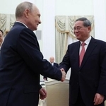 　中国の李強首相（右）と握手するロシアのプーチン大統領＝１８日、モスクワ（ロイター＝共同）