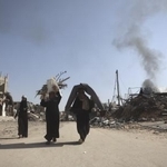 　ガザ南部ハンユニスで破壊された自宅から回収した衣類や毛布を運ぶパレスチナ人＝１８日（ゲッティ＝共同）