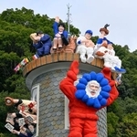 　大阪・関西万博のキャラクター「ミャクミャク」を思わせるコスチュームで登場した「世相サンタ」＝１９日午前、神戸・北野の異人館「うろこの家」