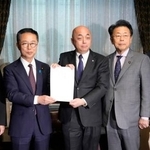 　政治資金規正法の改正案を衆院事務総長（中央）に提出する国民民主と公明両党の議員＝１９日午後、国会　