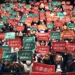 　１０月２８日、東京都内で開かれた集会で、プラカードを掲げ訴える原告や支援者ら