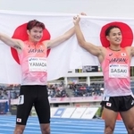 　男子２００メートルで２位となり、日の丸を掲げる山田真樹（左）と７位の佐々木琢磨＝駒沢陸上競技場