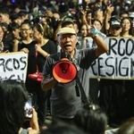 　フィリピンのマラカニアン宮殿近くに詰めかけ、マルコス大統領の辞任を求める人々＝９月、マニラ（共同）