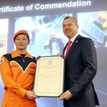 　式典で表彰状を受け取る、海上保安庁特殊救難隊の野田健斗隊長（左）＝２４日、ロンドンの国際海事機関本部（共同）