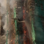 　２６日、煙が上がる香港北部の複数の住宅（ロイター＝共同）