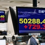 　日経平均株価の上げ幅が一時７００円を超え、５万円を回復したことを示すモニター＝２７日午前、東京都港区の外為どっとコム