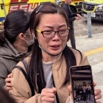 　火災が起きた高層住宅で一緒に住む娘を捜す母親（右）＝２７日、香港（共同）