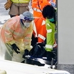 　火災現場から運び出される遺体を覆ったとみられる黒い袋＝２８日、香港北部・新界地区大埔（共同）