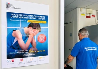 　通報機関「スポーツ・シグナル」のポスターが掲示されたパリ郊外の市民プール施設＝１１月（共同）
