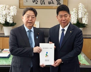 　林総務相（左）に地方自治法の改定案を手渡す川崎市の福田紀彦市長＝４日午前、総務省