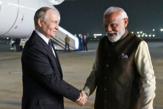 　４日、インド・ニューデリーに到着したロシアのプーチン大統領（左）を出迎えるモディ首相（タス＝共同）