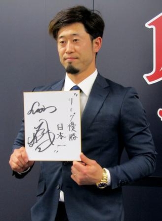 　契約更改交渉を終え、来季の抱負を記した色紙を掲げる西武・外崎＝５日、埼玉県所沢市