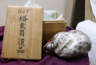 　医師菅野寛也さんが保管する、静岡空襲で墜落した米兵の遺品「黒焦げの水筒」＝１１月、静岡市