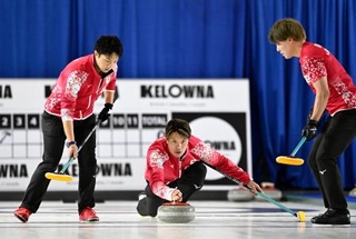 　男子１次Ｌ　米国戦の第２エンド、ショットを放つ山口。左は山本、右は小泉＝ケロウナ（共同）