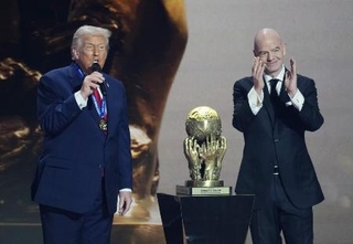 サッカーＷ杯北中米３カ国大会の組み合わせ抽選会でＦＩＦＡが新設した「平和賞」を受賞し、あいさつするトランプ米大統領。右はインファンティノ会長＝５日、米ワシントン（共同）