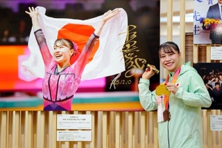　「２０２５年報道写真展」で、自身の写真にサインする体操女子の杉原愛子選手＝１０日午前、東京都中央区の日本橋三越本店