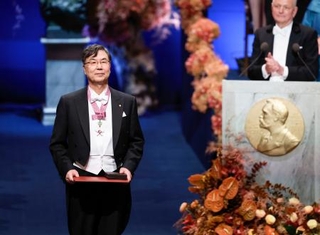 　ノーベル賞授賞式で、生理学・医学賞のメダルと賞状を授与された坂口志文・大阪大特任教授＝１０日、ストックホルムのコンサートホール（共同）