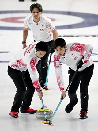 　男子プレーオフ　中国戦の第６エンド、スイープする柳沢（右）と山本。奥は小泉＝ケロウナ（共同）