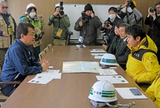 　青森県の宮下知事（右手前）から被害状況の説明を受ける国民民主党の玉木代表＝１２日午後、青森県八戸市