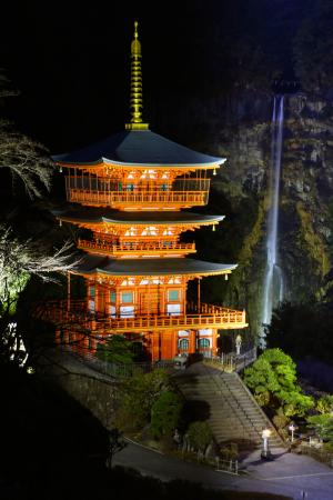 　試験点灯が行われた「那智の滝」と青岸渡寺の「三重塔」＝１９日夜、和歌山県那智勝浦町