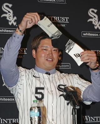 　ホワイトソックスの入団記者会見で靴下を掲げる村上宗隆内野手＝２２日、シカゴ（共同）