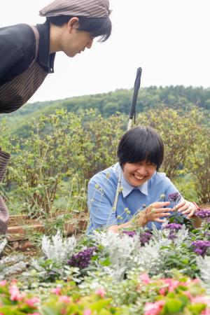 　「香りの里ハーブガーデン」で花の匂いを楽しむ片岡裕里さん（右）＝７月、北海道滝上町