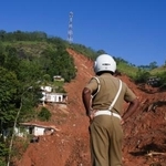 　２日、スリランカ中部キャンディで、豪雨による土砂崩れの現場を見る警察官（ロイター＝共同）