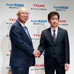 　記者会見で握手する帝人フロンティアの平田恭成社長（左）と旭化成アドバンスの春見恵司社長＝２日午後、東京都内