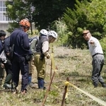 　北海道福島町で、ヒグマに襲われた男性が倒れていた現場付近を調べる町役場職員ら＝７月