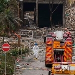 　火災が起きた高層住宅群周辺で消火ホースを片付ける消防士＝４日、香港（共同）