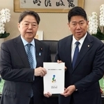 　林総務相（左）に地方自治法の改定案を手渡す川崎市の福田紀彦市長＝４日午前、総務省