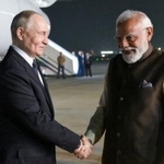 　４日、インド・ニューデリーに到着したロシアのプーチン大統領（左）を出迎えるモディ首相（タス＝共同）