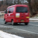 　うっすらと雪が積もった岩手県内の山間部を走る郵便局の軽バン＝１１月