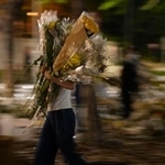 　高層住宅群の大規模火災現場近くの公園から撤去される花束＝７日、香港（共同）